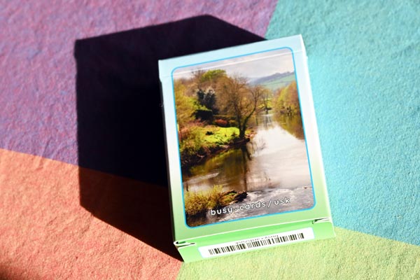 A box of Usk cards lies on a table, showing the photograph of the river Usk